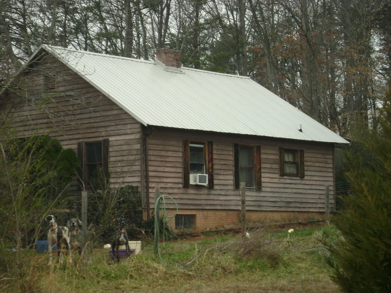 White metal roof on an old wood sided farmhouse, from a Asphalt Shingle Roof Repair job in Ladson